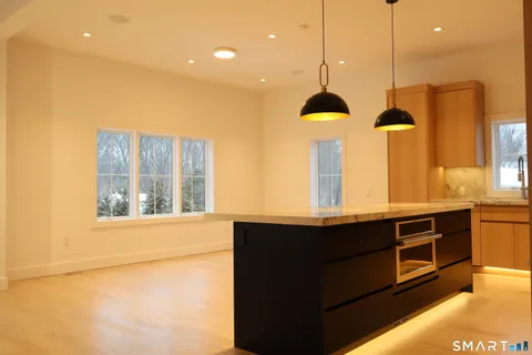 a kitchen with stainless steel appliances granite countertop a sink a stove and a window