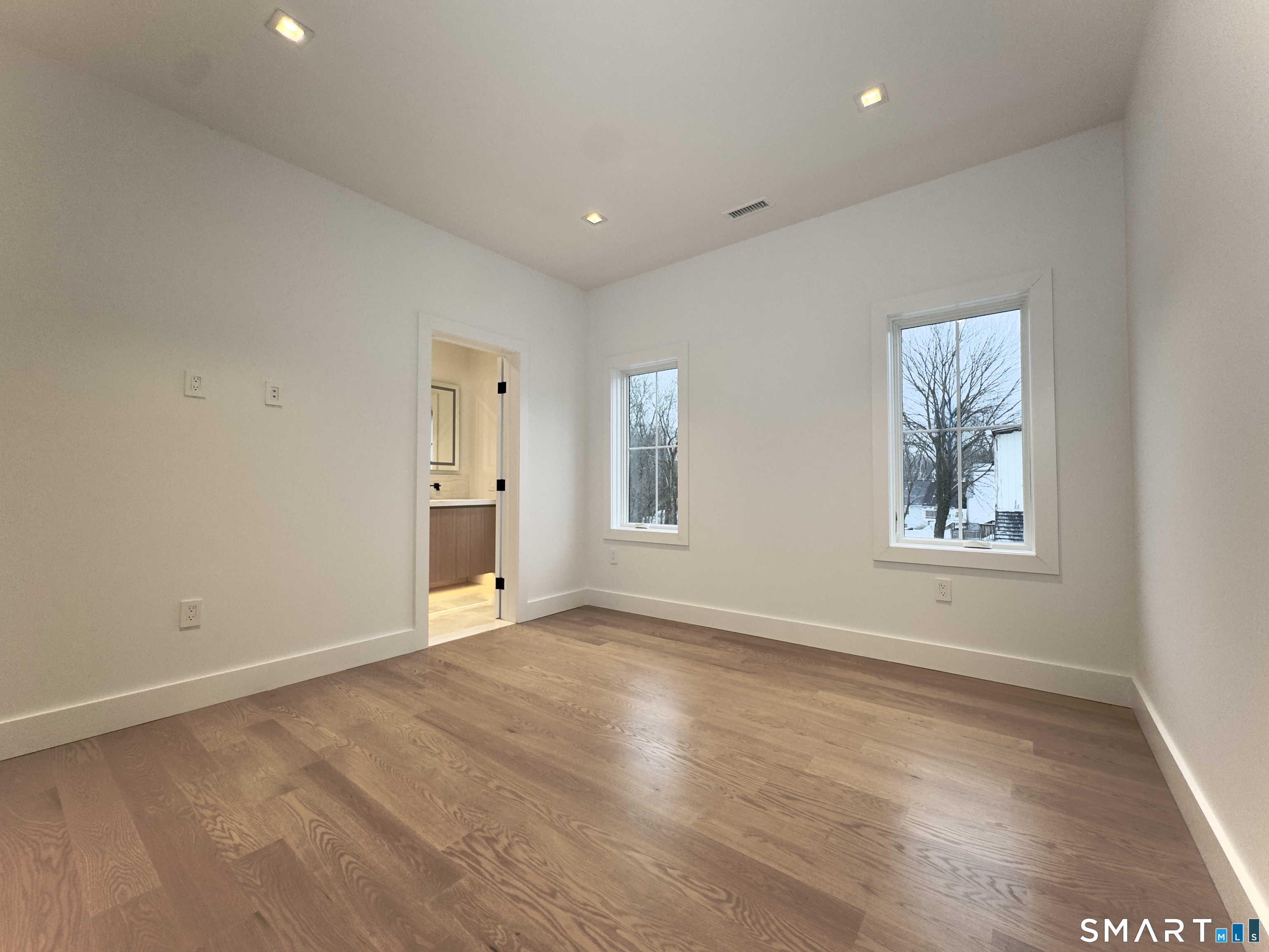 173 Belltown Road Stamford, CT 06905 - Photo 20 of 31 a view of an empty room with a window and wooden floor