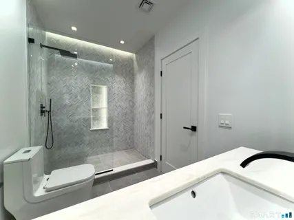 a bathroom with a sink a toilet and shower