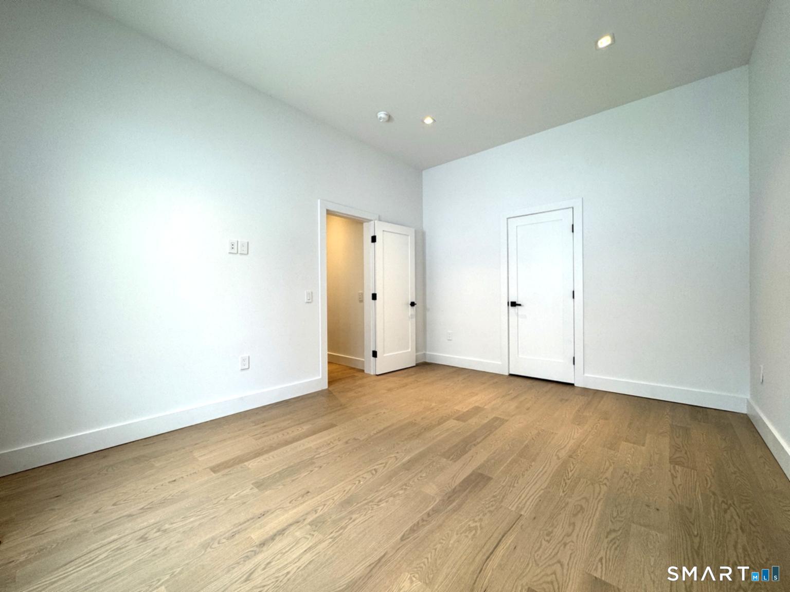 173 Belltown Road Stamford, CT 06905 - Photo 31 of 42 an empty room with wooden floor