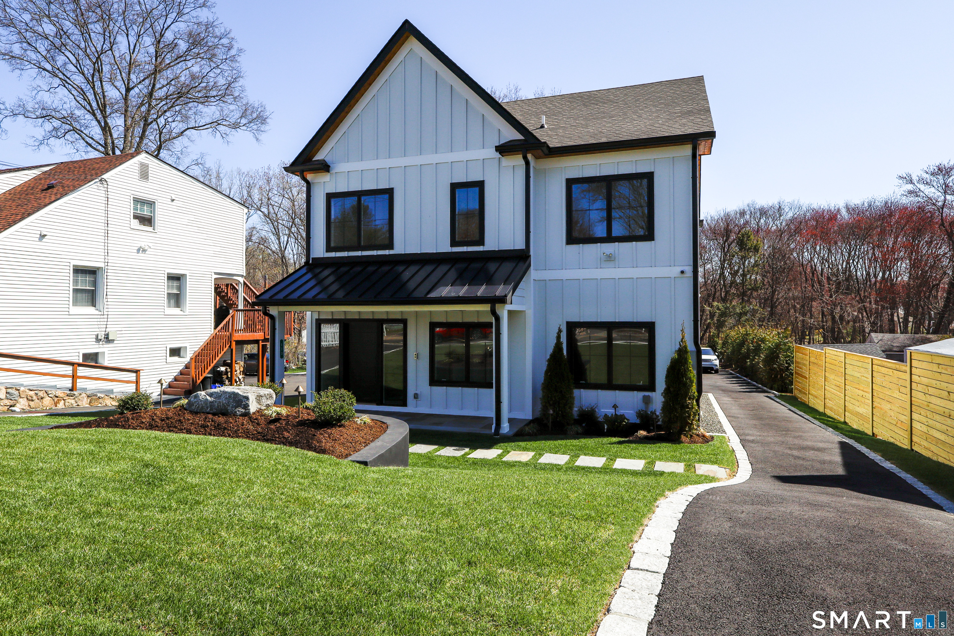 173 Belltown Road Stamford, CT 06905 - Photo 4 of 42 a view of a house with a yard and a wooden fence