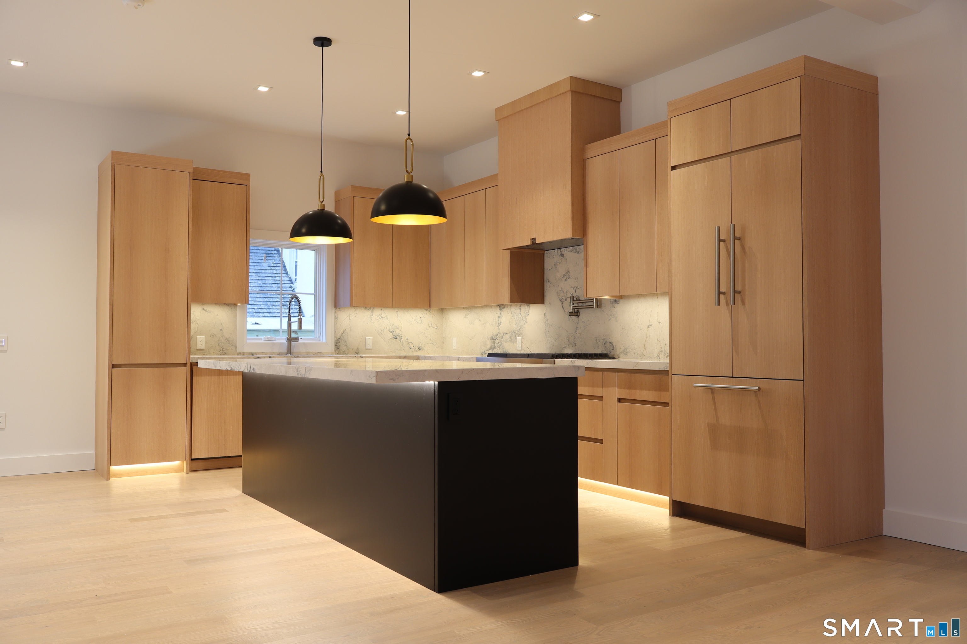 173 Belltown Road Stamford, CT 06905 - Photo 7 of 31 a kitchen with kitchen island granite countertop a refrigerator a sink and wooden floor