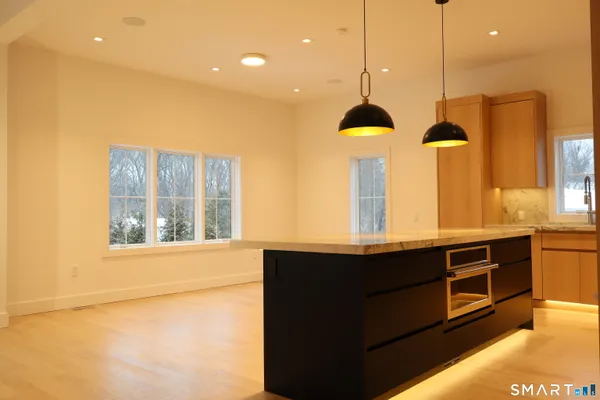 a kitchen with stainless steel appliances granite countertop a sink a stove and a window