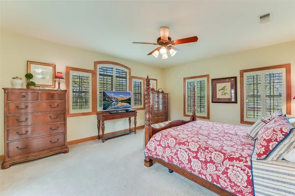 a spacious bedroom with a bed a dresser and a window