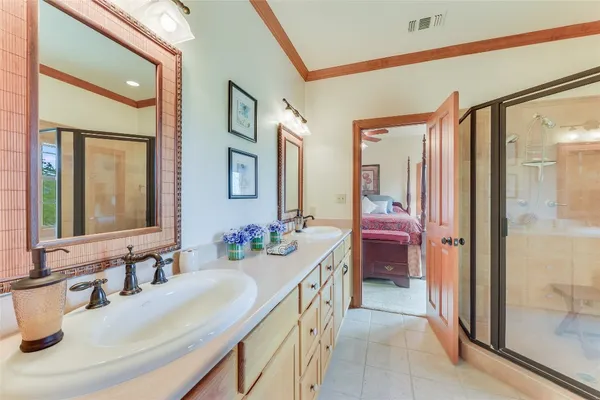a bathroom with a double vanity sink mirror and shower