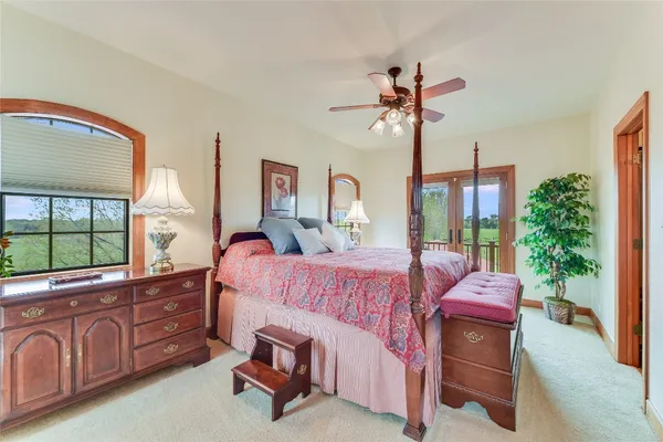 a bedroom with a bed a chandelier and dresser