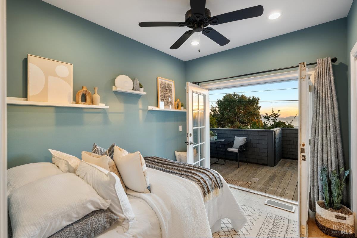 700 Ocean Avenue Point Richmond, CA 94801 - Photo 42 of 95 a bedroom with a bed a flat screen tv and a large window