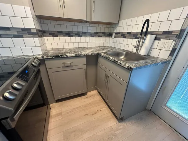 a kitchen with a sink stove and cabinets