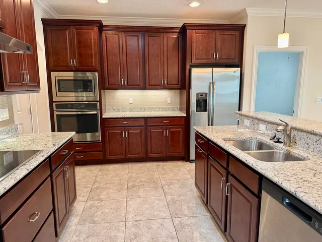 a kitchen with stainless steel appliances granite countertop a sink stove and refrigerator