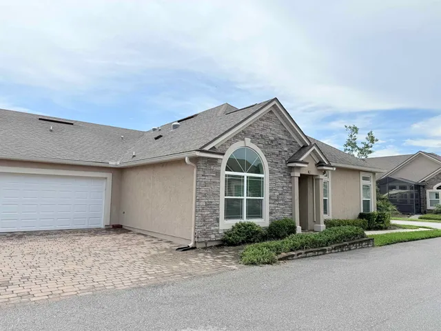 a view of a white house next to a yard