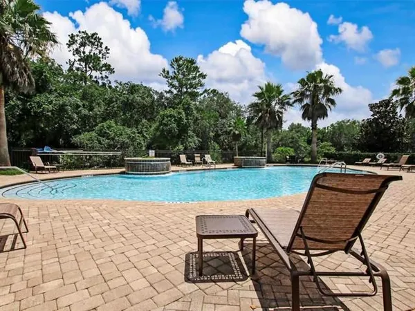 a view of a house with swimming pool and sitting area