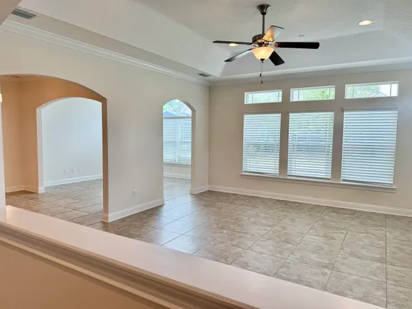 a view of empty room with ceiling fan and window