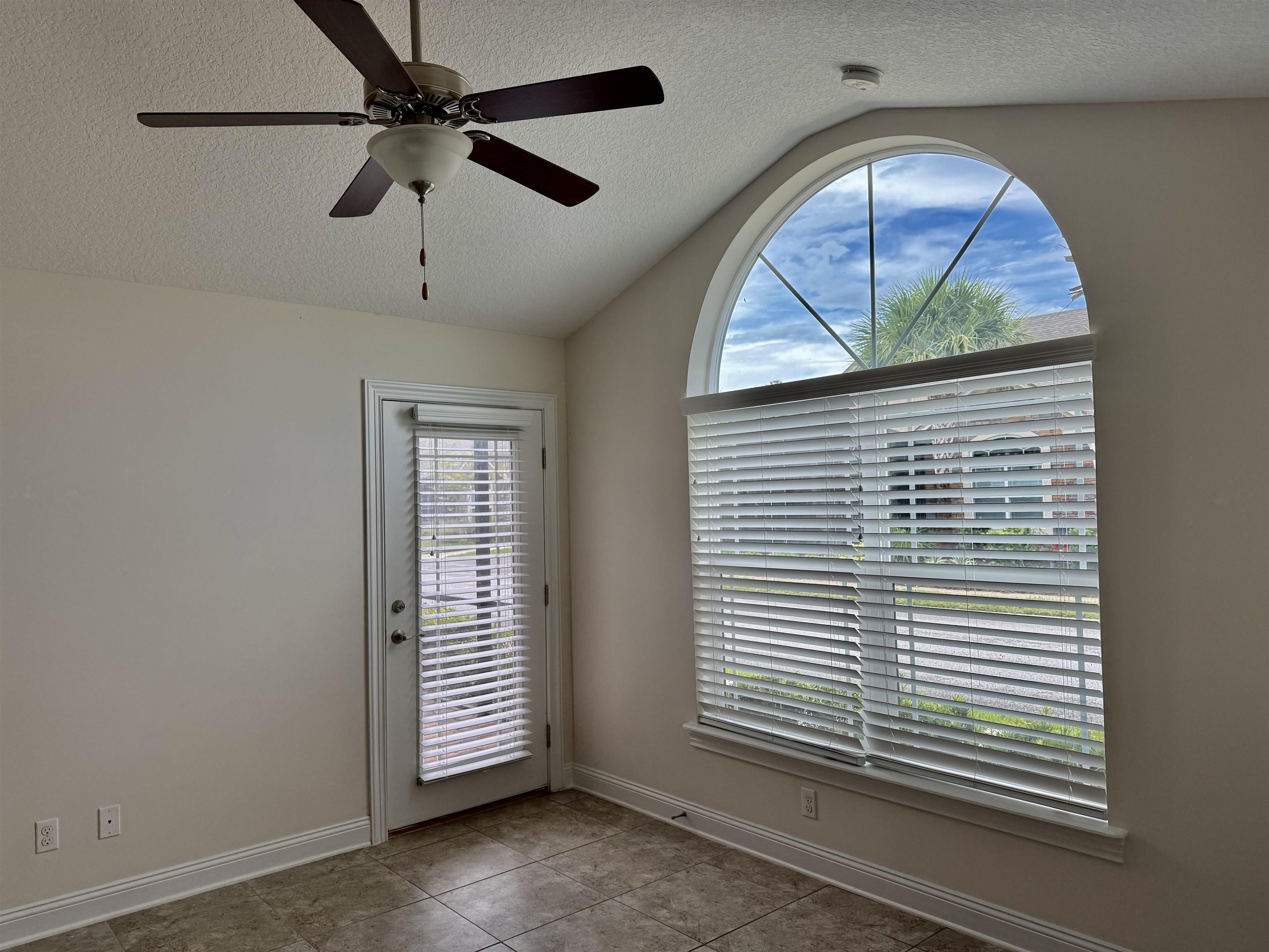 71 Utina Way St. Augustine, FL 32084 - Photo 8 of 37 an empty room with wooden floor chandelier fan and windows