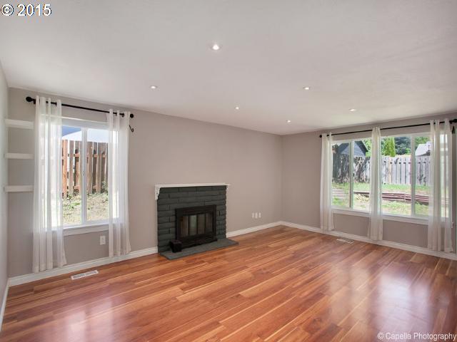19705 Southwest Prospect Lane Aloha, OR 97078 - Photo 2 of 16 a view of empty room with wooden floor and fireplace