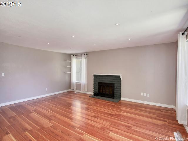 19705 Southwest Prospect Lane Aloha, OR 97078 - Photo 3 of 16 a view of an empty room with wooden floor fireplace and a window
