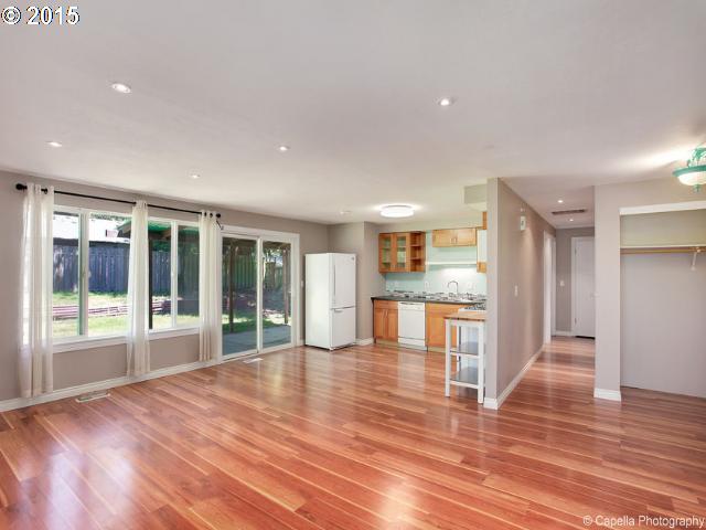 19705 Southwest Prospect Lane Aloha, OR 97078 - Photo 4 of 16 a view of an empty room with wooden floor and a kitchen