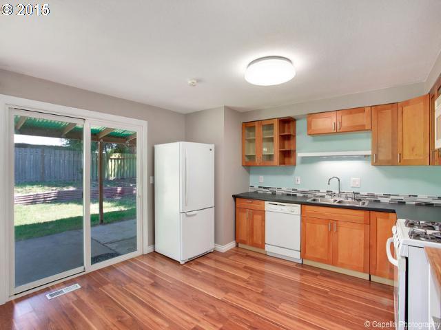 19705 Southwest Prospect Lane Aloha, OR 97078 - Photo 6 of 16 a kitchen with granite countertop a refrigerator and a sink