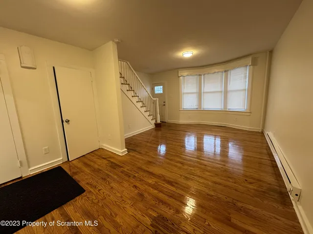 a view of empty room with wooden floor