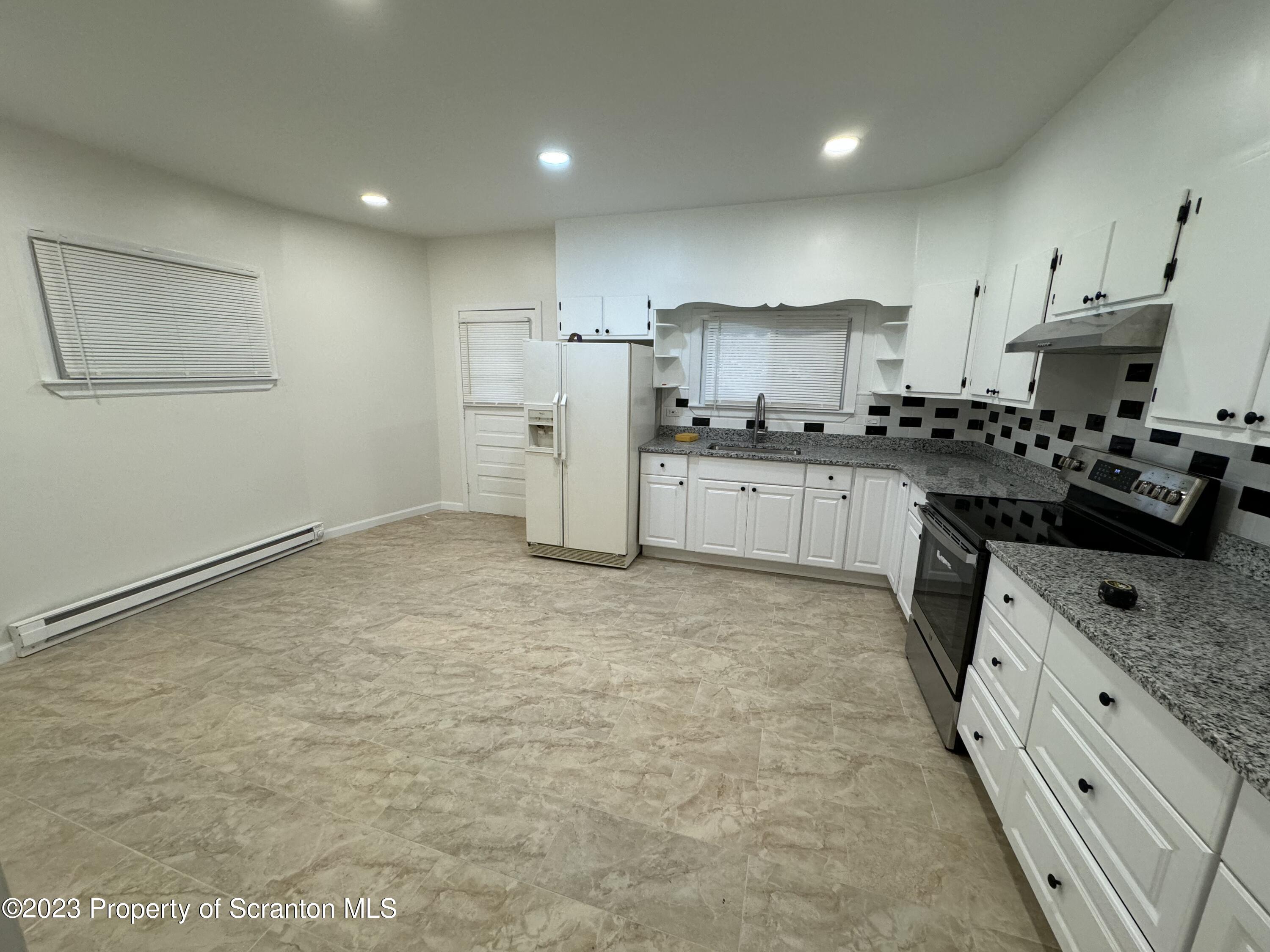 318 1/2 14th Avenue Scranton, PA 18504 - Photo 5 of 10 a kitchen with stainless steel appliances granite countertop a stove a sink and a refrigerator