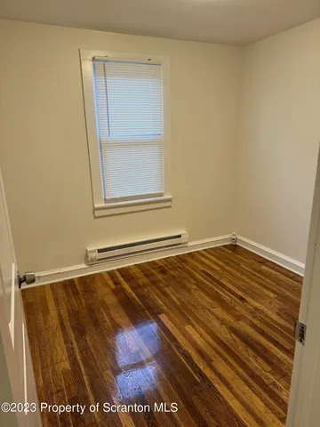 a view of a room with wooden floor and cabinet