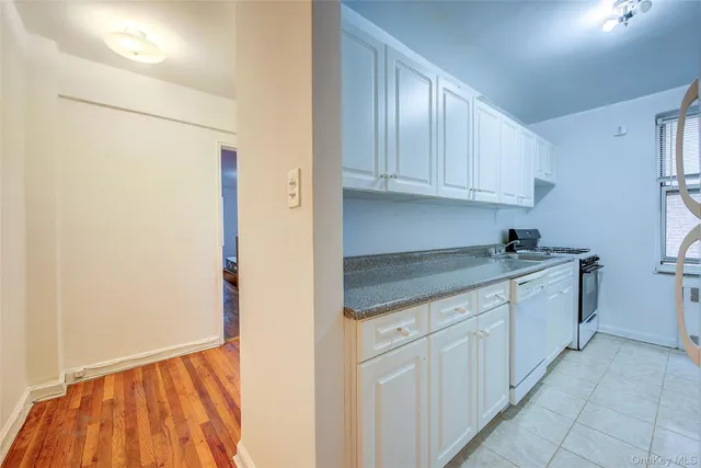 a kitchen with granite countertop white cabinets and white appliances