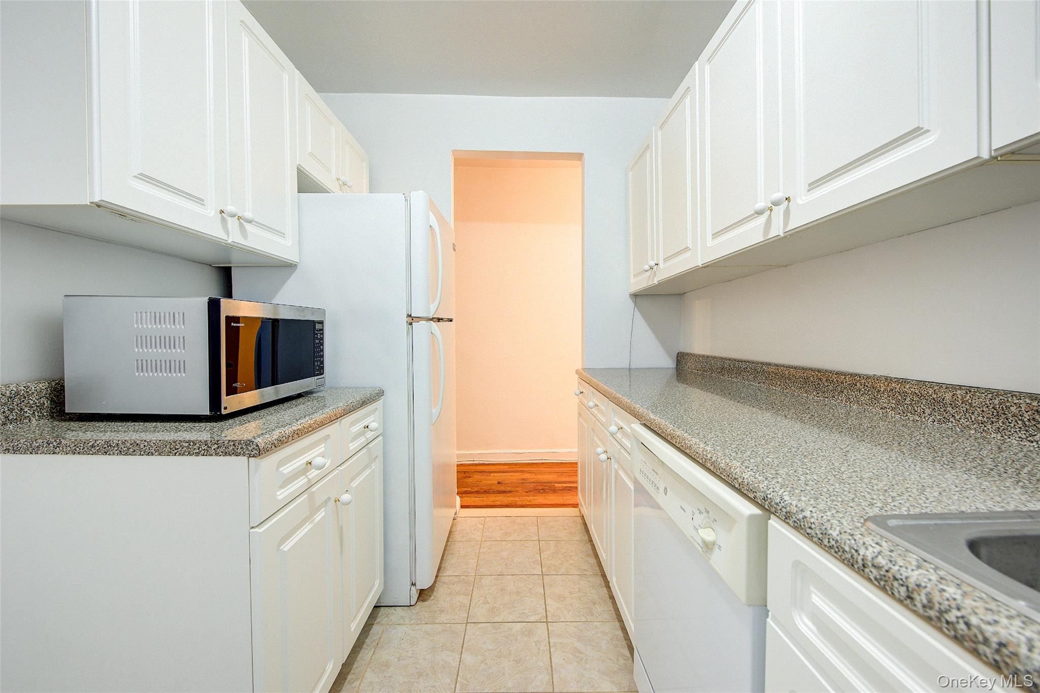 67-12 Yellowstone Boulevard, Unit D9 Queens, NY 11375 - Photo 16 of 36 a kitchen with granite countertop a sink and a stove top oven