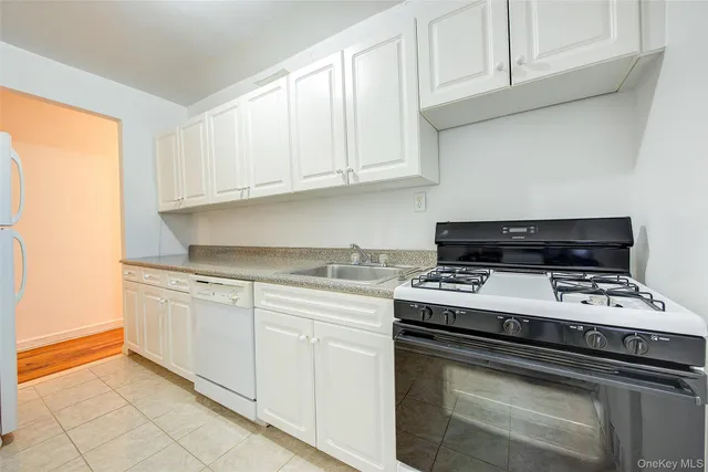 a kitchen with granite countertop white cabinets and black appliances