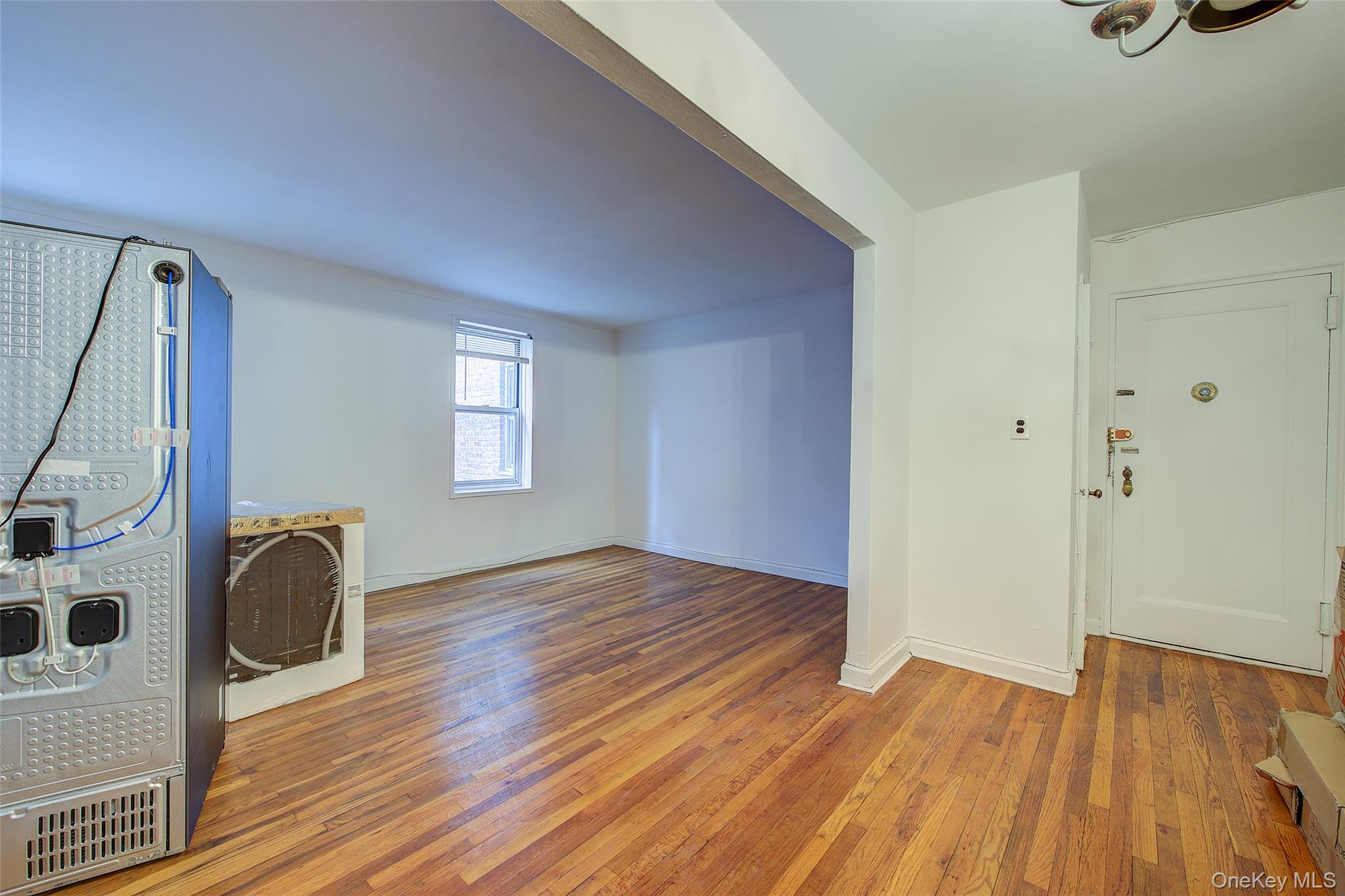67-12 Yellowstone Boulevard, Unit D9 Queens, NY 11375 - Photo 31 of 36 an empty room with wooden floor and windows