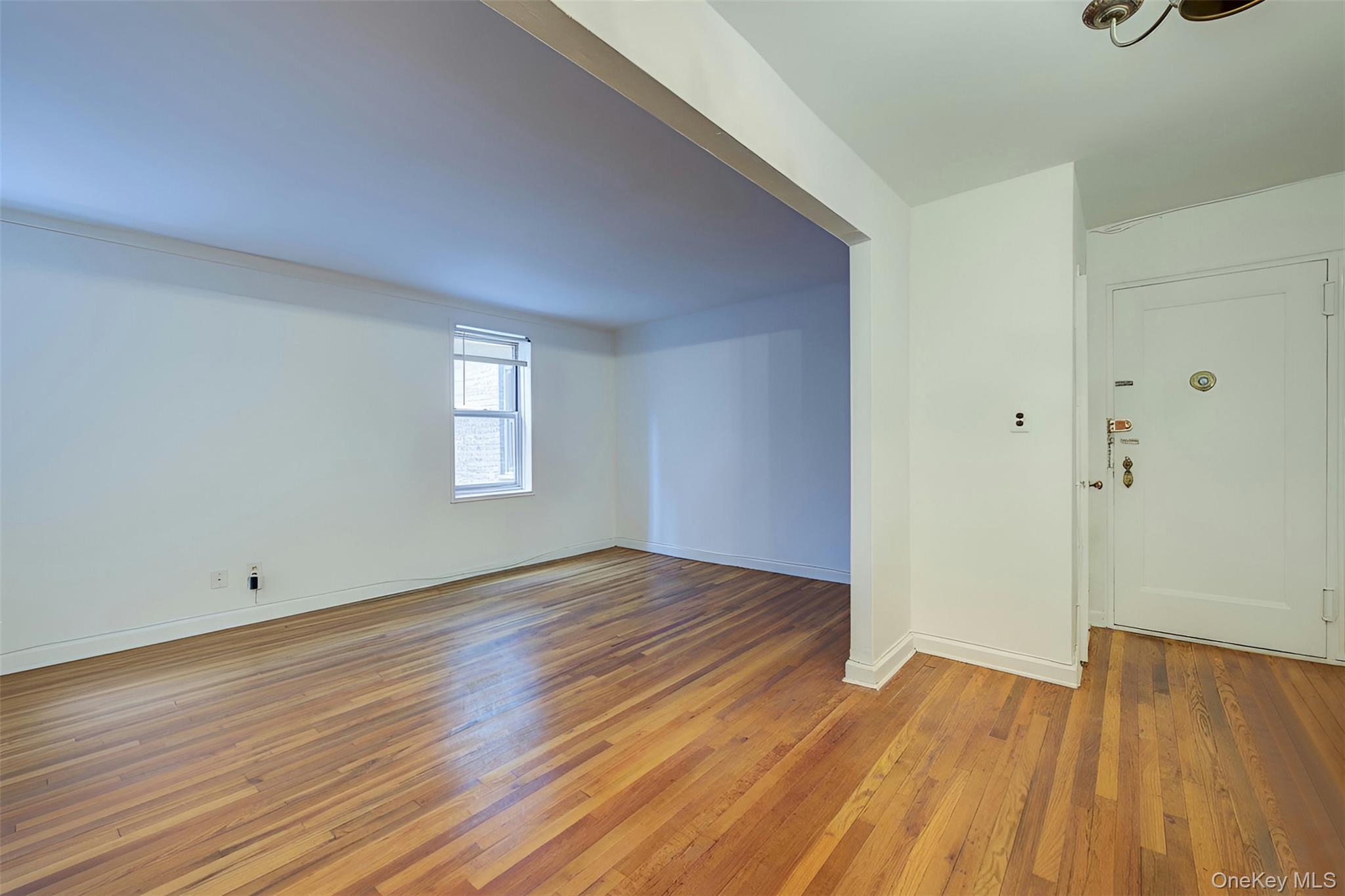 67-12 Yellowstone Boulevard, Unit D9 Queens, NY 11375 - Photo 32 of 36 a view of an empty room with wooden floor and a window