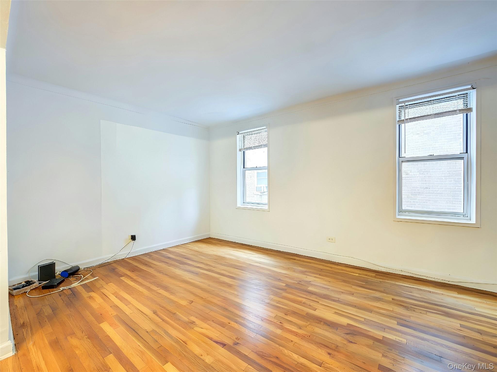 67-12 Yellowstone Boulevard, Unit D9 Queens, NY 11375 - Photo 9 of 36 a view of empty room with wooden floor and fan