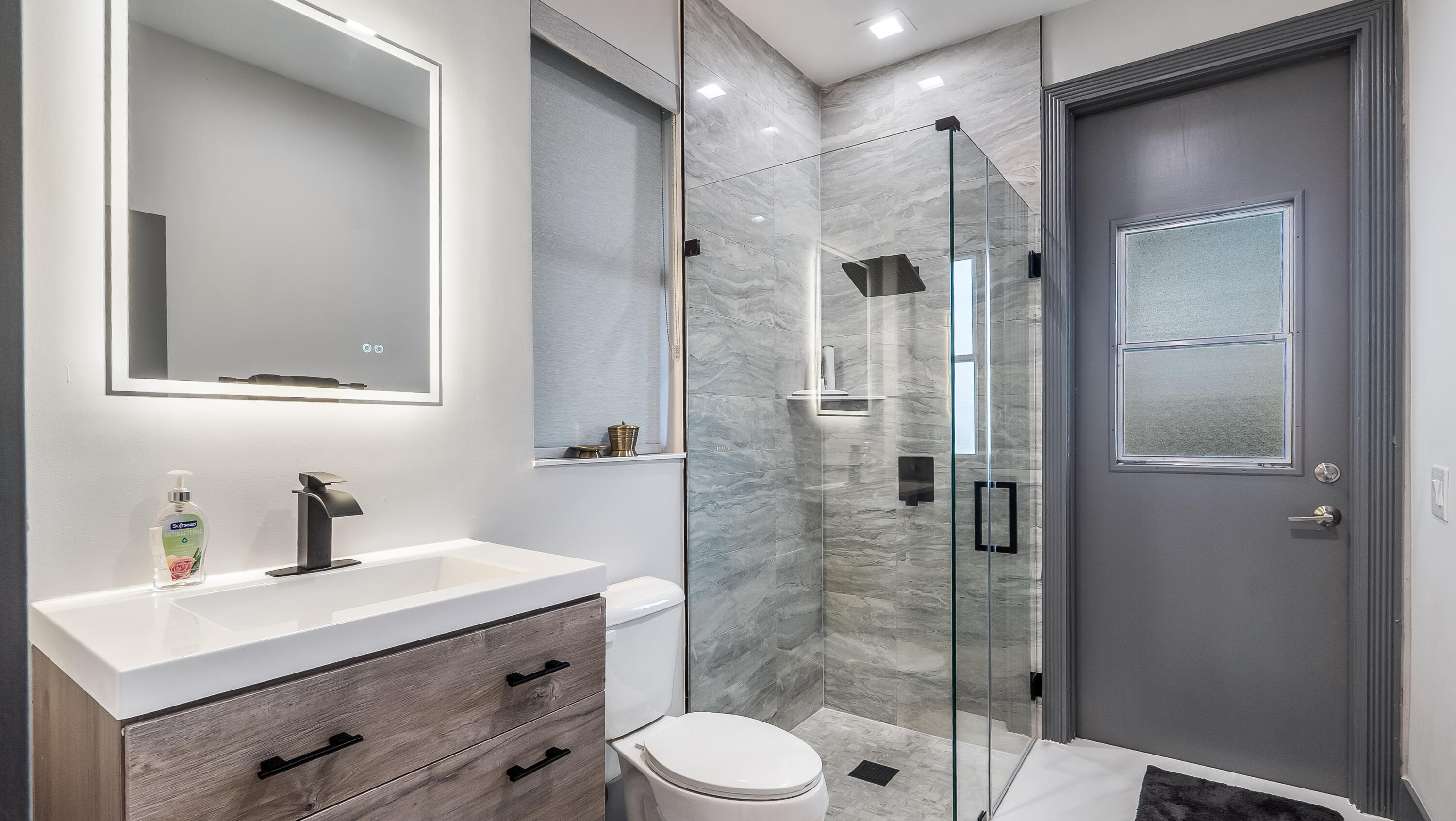 17683 Sealakes Drive Boca Raton, FL 33498 - Photo 37 of 61 a bathroom with a sink toilet a mirror and shower