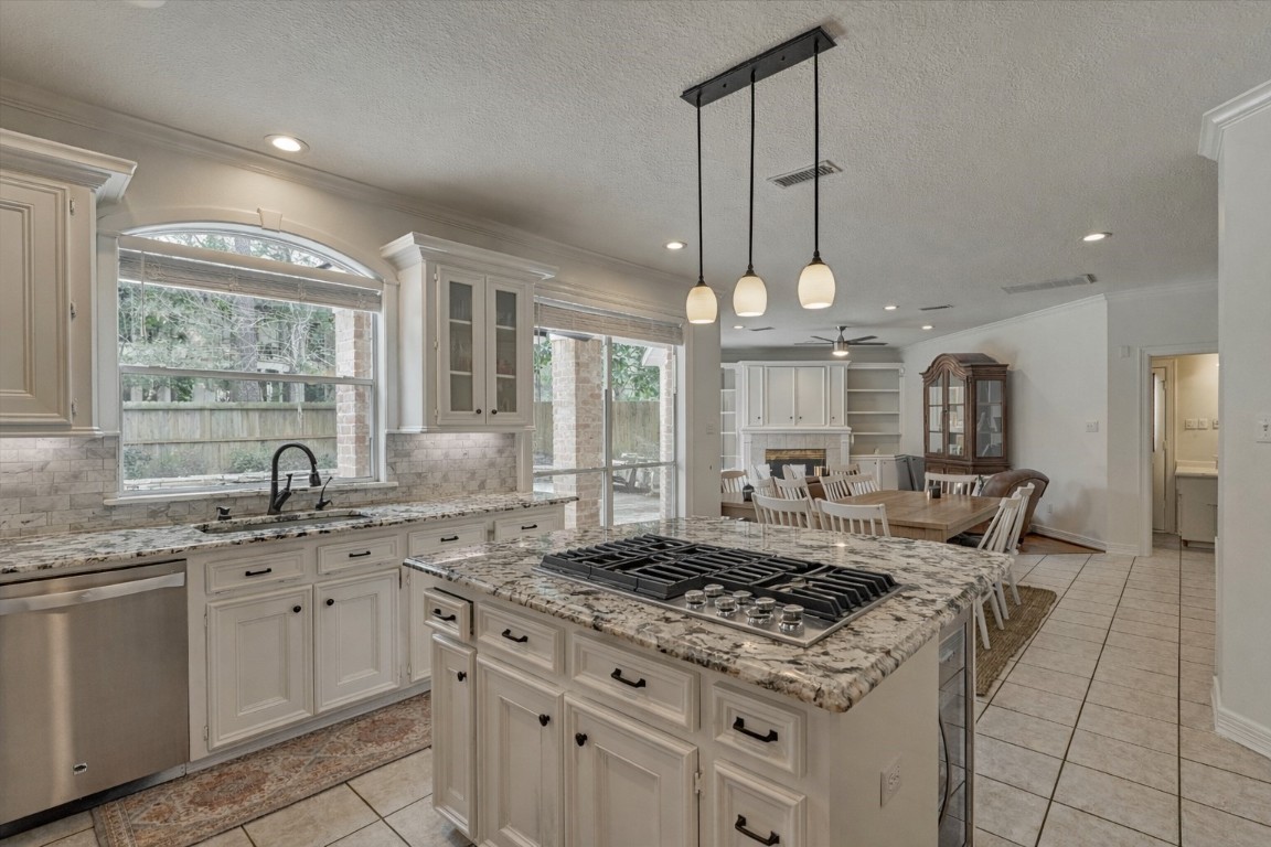 91 Wind Ridge Circle The Woodlands, TX 77381 - Photo 11 of 50 The kitchen blends seamlessly with the breakfast room and den, offering ultimate flow and functionality. Note: dining bar seating at the island for eat-in kitchen options.