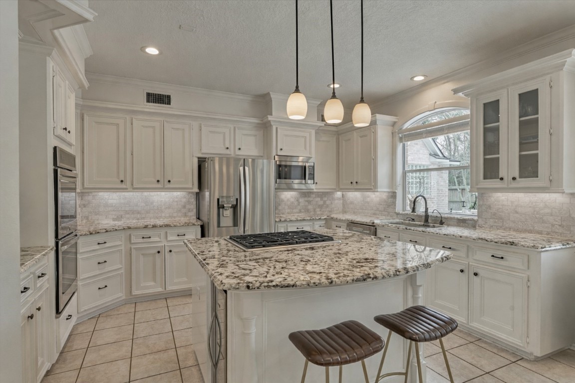 91 Wind Ridge Circle The Woodlands, TX 77381 - Photo 8 of 50 Welcome to a gourmet chef's kitchen with stainless steel appliances, a wine cooler, and more!