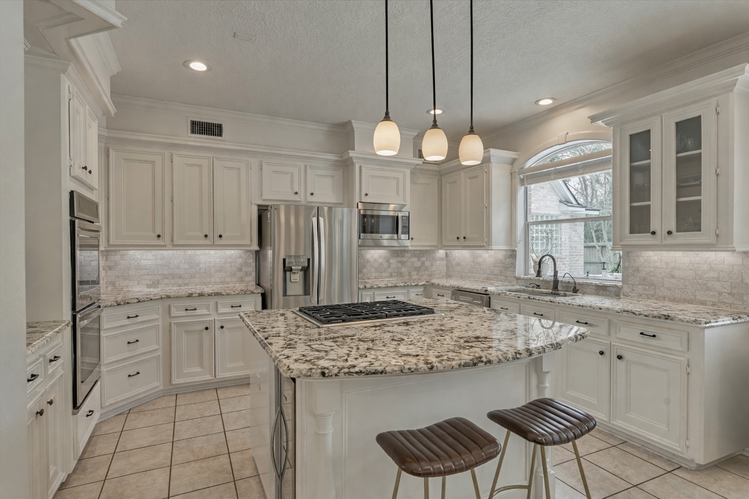 91 Wind Ridge Circle Spring, TX 77381 - Photo 10 of 50 Welcome to the gourmet chef's kitchen with stainless steel appliances, a wine cooler, and more!