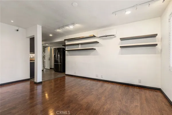 a view of an empty room with wooden floor