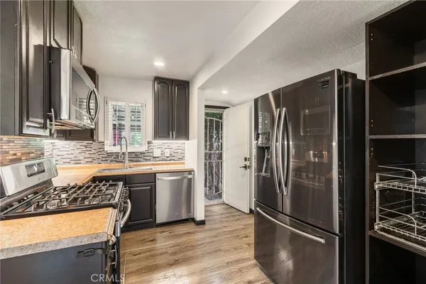 a kitchen with stainless steel appliances granite countertop a refrigerator and a stove top oven