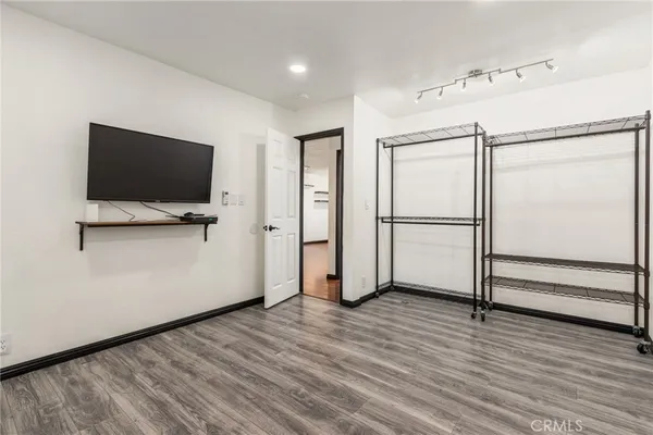 a view of a livingroom with wooden floor and a flat screen tv