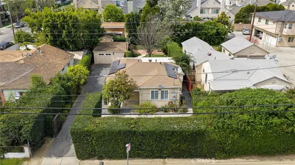 an aerial view of a house with outdoor space and a lake view in back