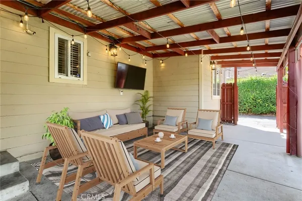 a outdoor living space with furniture and a flat screen tv