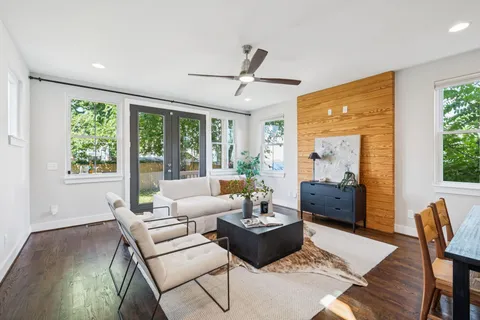 a living room with furniture potted plant and a large window