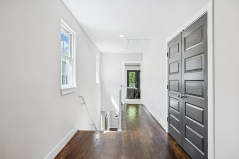 a bedroom with a bed and large windows