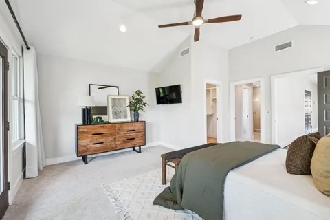 a spacious bedroom with a bed and glass door
