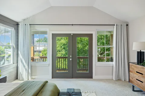 a spacious bedroom with a bed and glass door