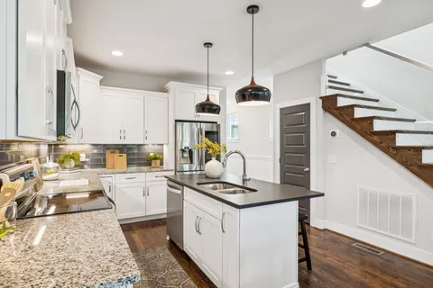 a kitchen with granite countertop a sink a counter top space appliances and cabinets
