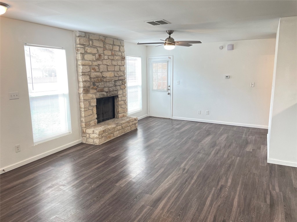 12810 Broughton Way, Unit A Austin, TX 78727 - Photo 2 of 16 an empty room with wooden floor fireplace and windows