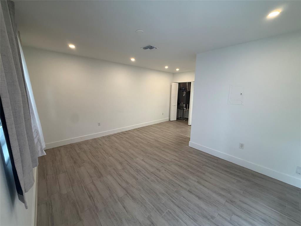 Undisclosed Address Miami, FL 33125 - Photo 2 of 9 an empty room with wooden floor and entrance