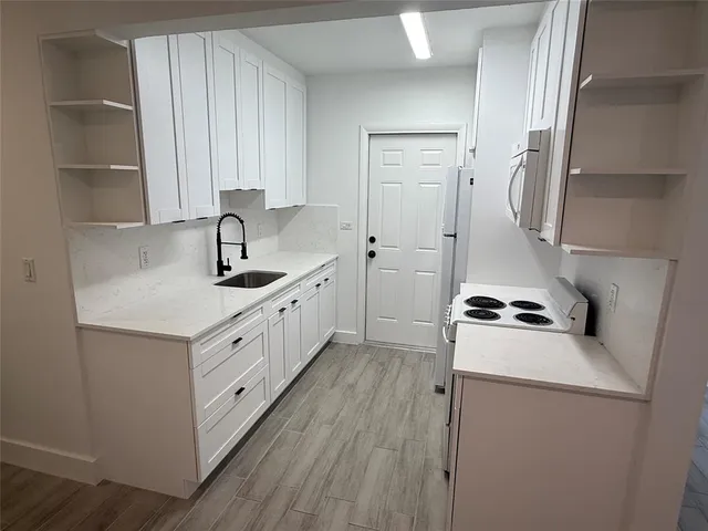 a kitchen with white cabinets and white appliances