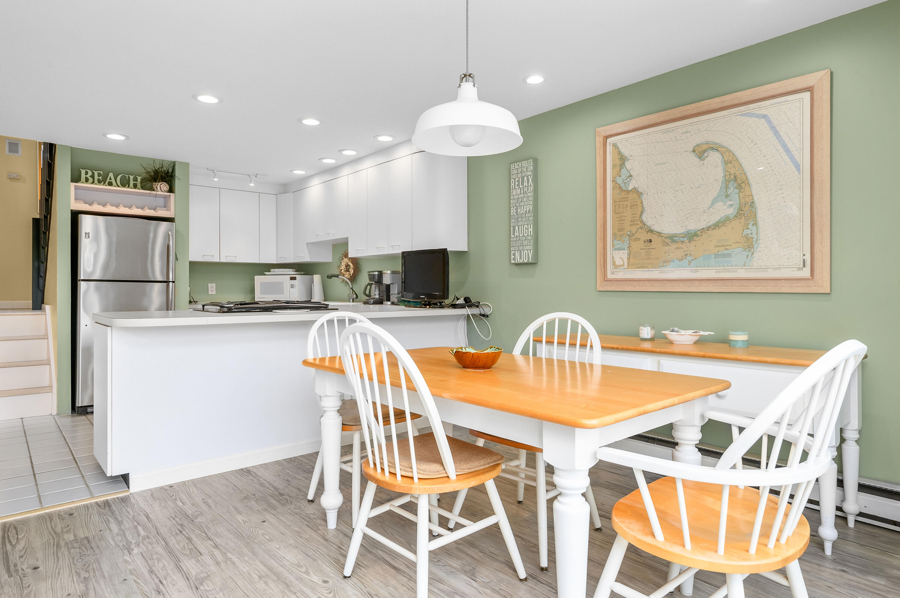 500 Ocean Street, Unit 68 Hyannis, MA 02601 - Photo 6 of 39 a kitchen with stainless steel appliances granite countertop a dining table chairs refrigerator and microwave