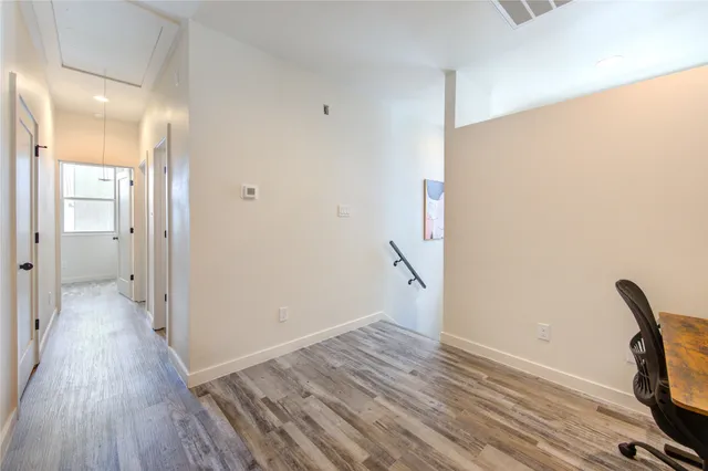 a view of a workspace with wooden floor and a window