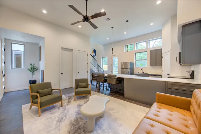 a living room with furniture a flat screen tv and a large window